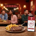 Application de fidélité Hippopotamus sur une table de restaurant avec une entrecôte.