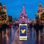 Main Street USA à Disneyland Paris au crépuscule avec un smartphone affichant le Disneyland Pass Gold.