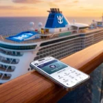 Smartphone affichant le statut Crown & Anchor Society de Royal Caribbean sur un balcon de navire de croisière.