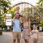 Famille utilisant le Pass Saison numérique sur smartphone à l'entrée du Parc Astérix.