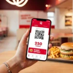 Client utilisant son smartphone pour scanner l'application de fidélité Quick et obtenir un burger Giant gratuit.
