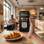 Client présentant son Pass fidélité numérique La Croissanterie sur son smartphone lors d'une pause café.